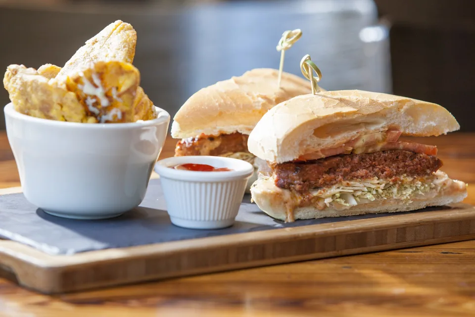 Sandwich and fries served on a wooden board