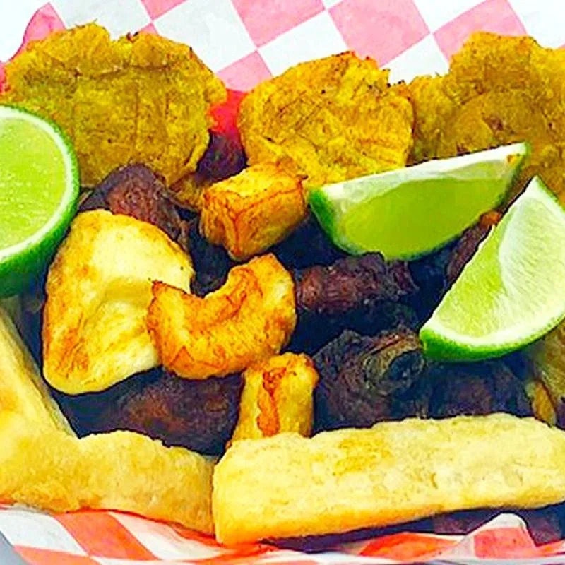 Basket of tostones, fried cheese and yuca with lime wedges