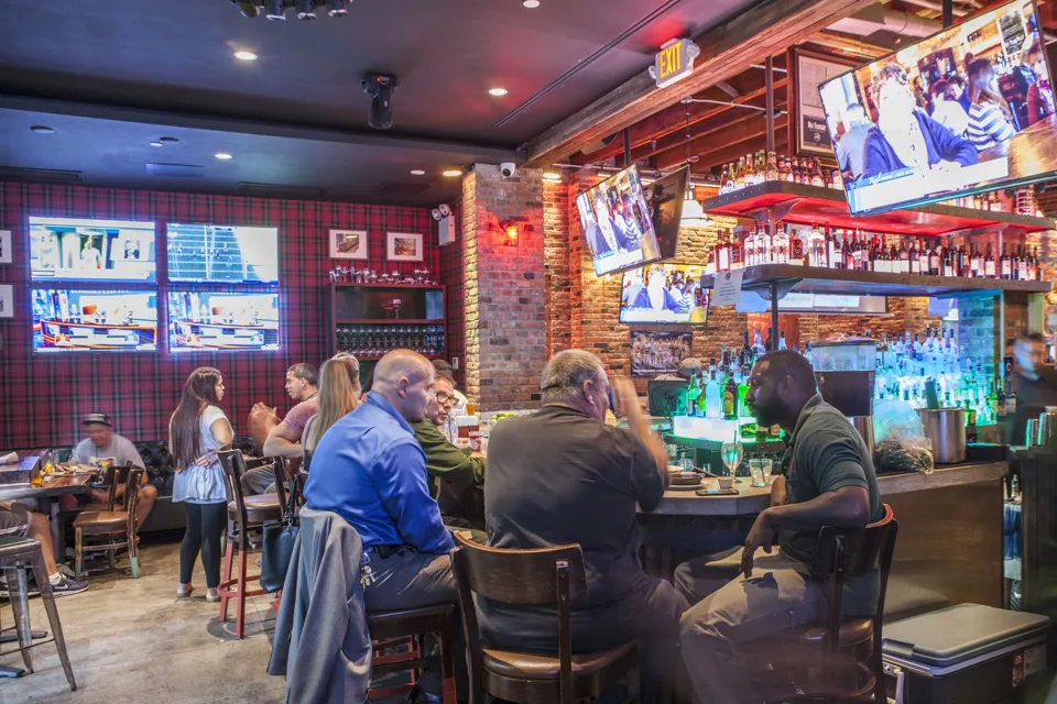 The bar room with TVs on a busy night